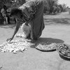 A woman in Northern Uganda dries vegetables in the sun. 