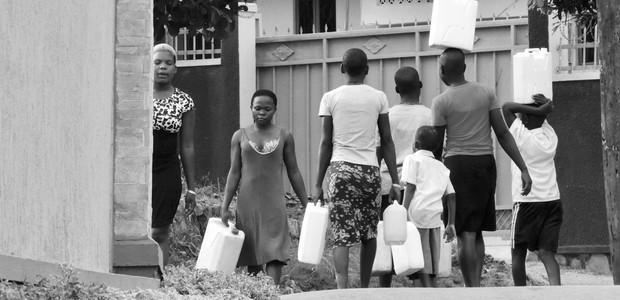 Women and children carrying jerry cans filled with water. (photo: The Niles | Henry Lutaaya)