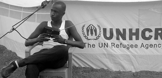 A South Sudanese seeking refuge in Northern Uganda listens to the radio. (photo: The Niles | Ochan Hannington)